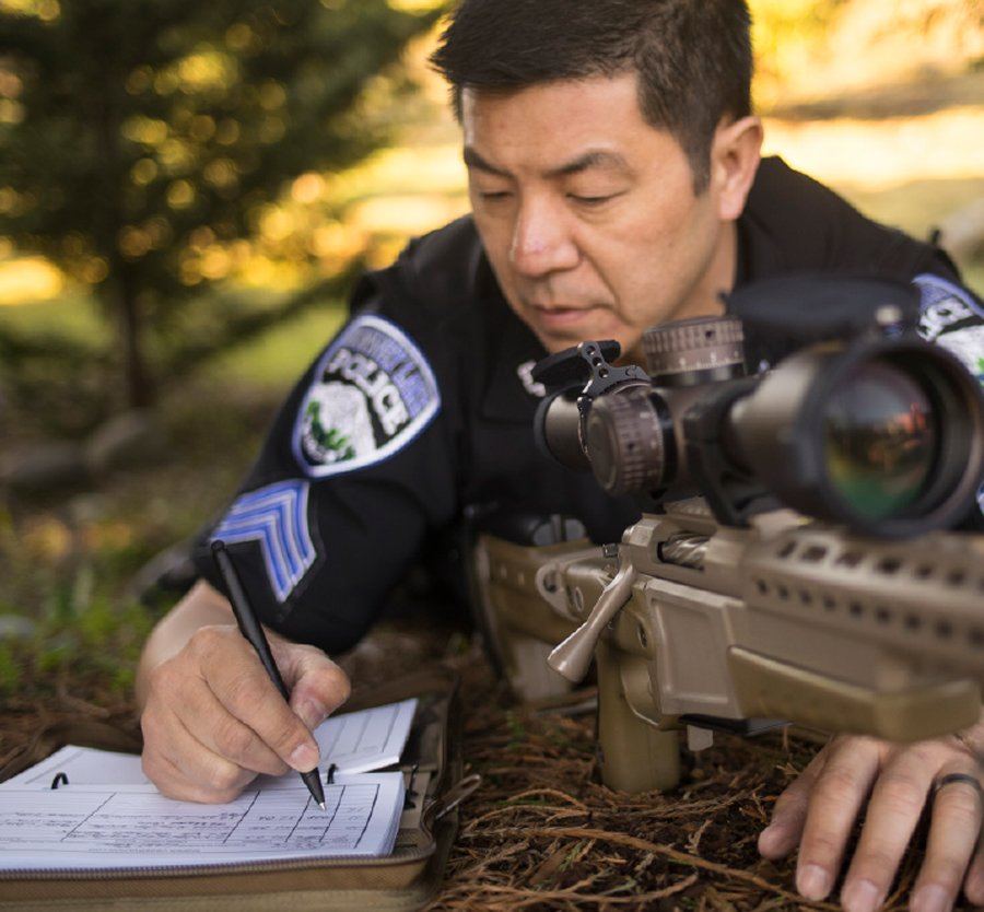 Officer Ron recording range data on weather proof notebook.