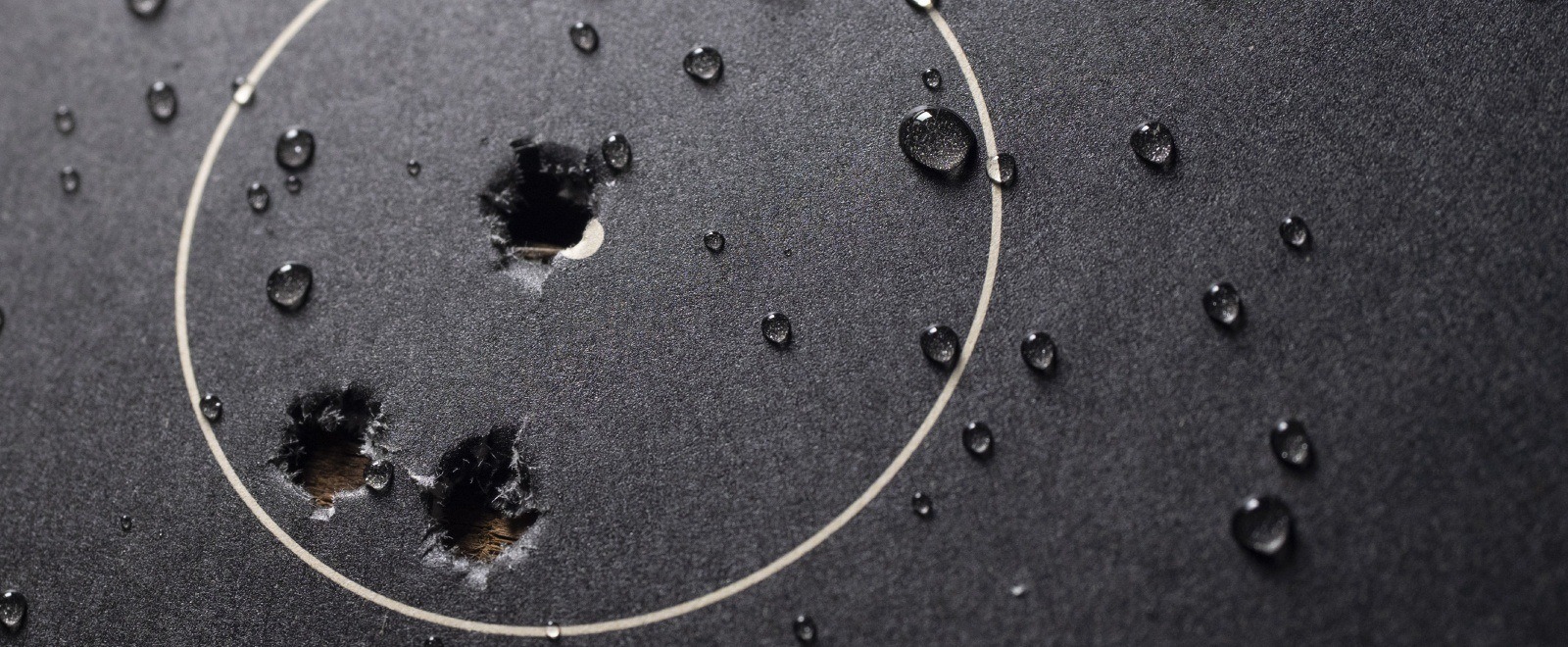 Close up of bullet holes on wet target.