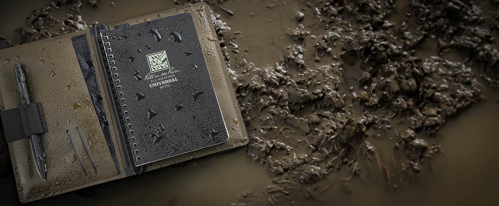 Tracker cover with notebook and pen on muddy background
