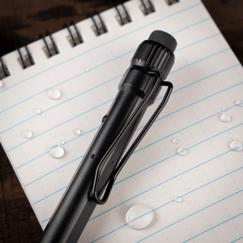Twist pencil resting on notebook with writting through water drops.